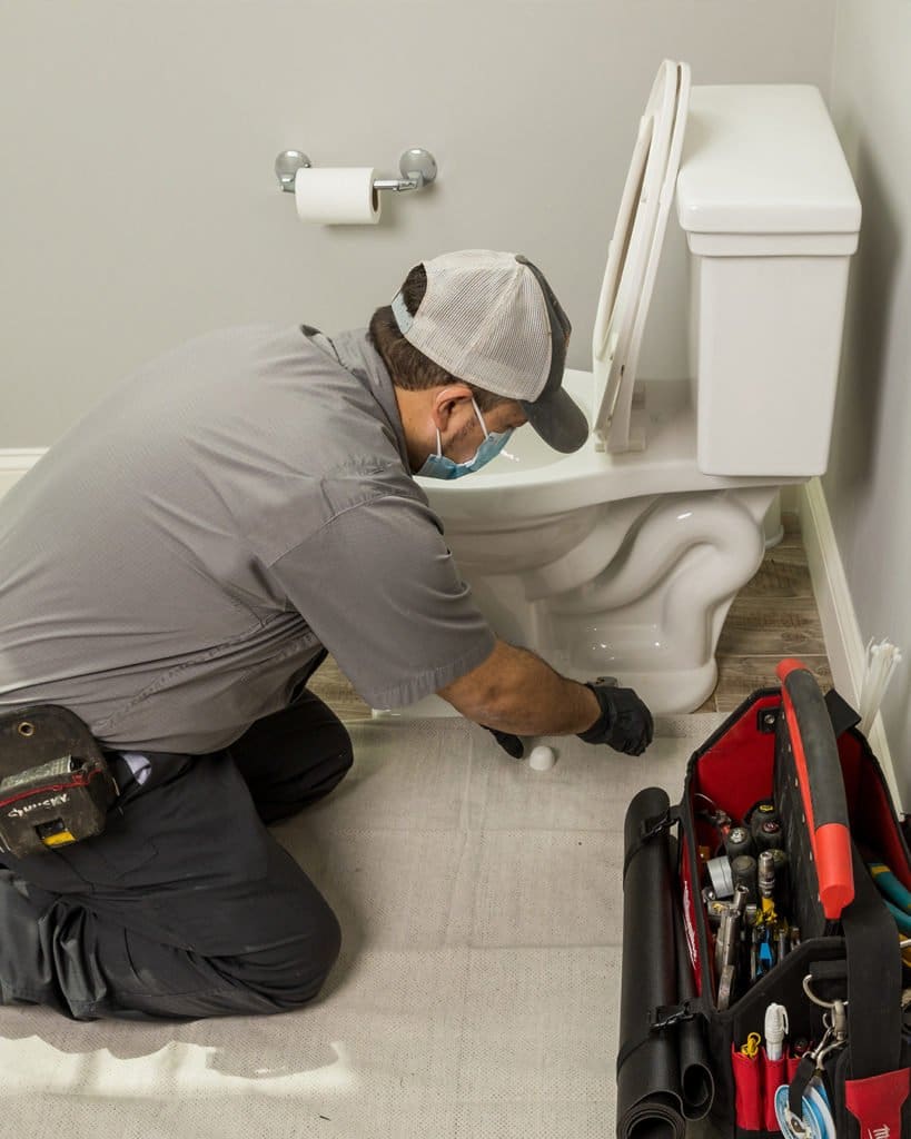 Technician remodeling a plumbing fixture, fixing a toilet, installing a toilet
